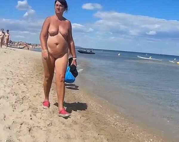 Извращенец ходит по нудистскому пляжу и снимает голых женщин